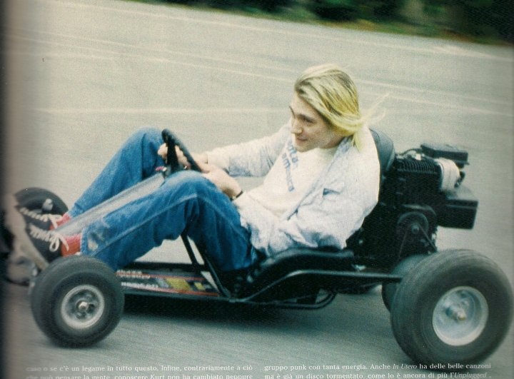 a woman is riding an electric go - kart in the street with her feet on the ground