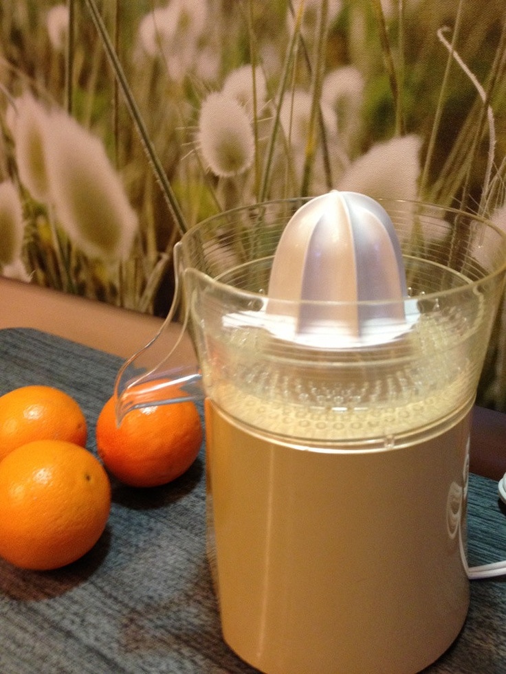 an electric juicer sitting on top of a table next to oranges