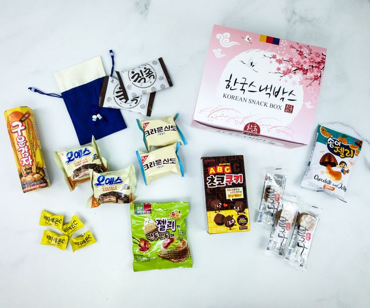 an assortment of snacks and candy on a white counter top with japanese characters in the background