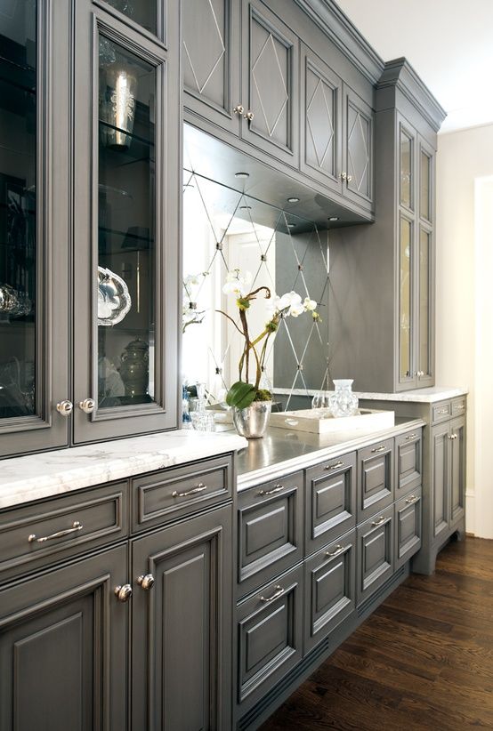 a large kitchen with gray cabinets and marble counter tops