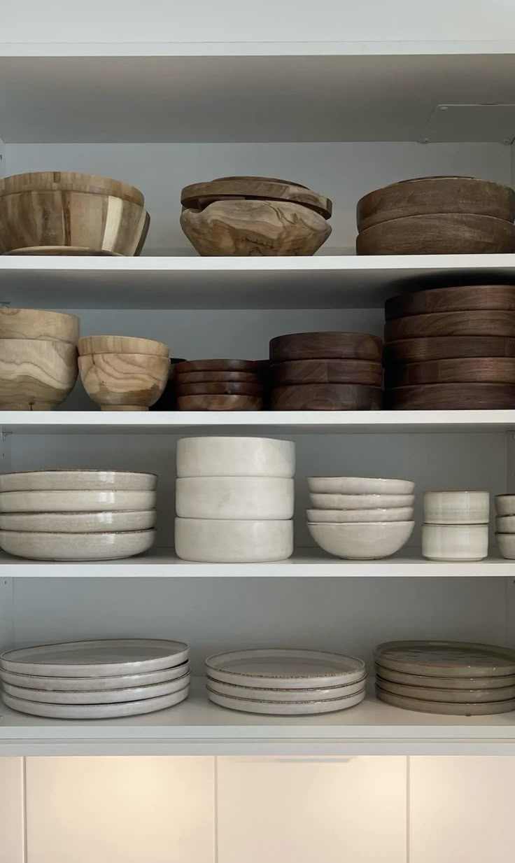 the shelves are filled with bowls and plates