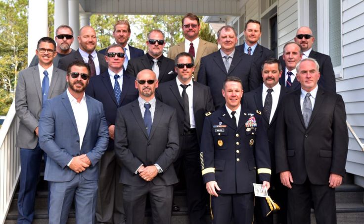 a group of men in suits and ties are posing for a photo on the steps