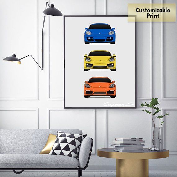 three cars in different colors on a white wall above a gray couch with a gold coffee table