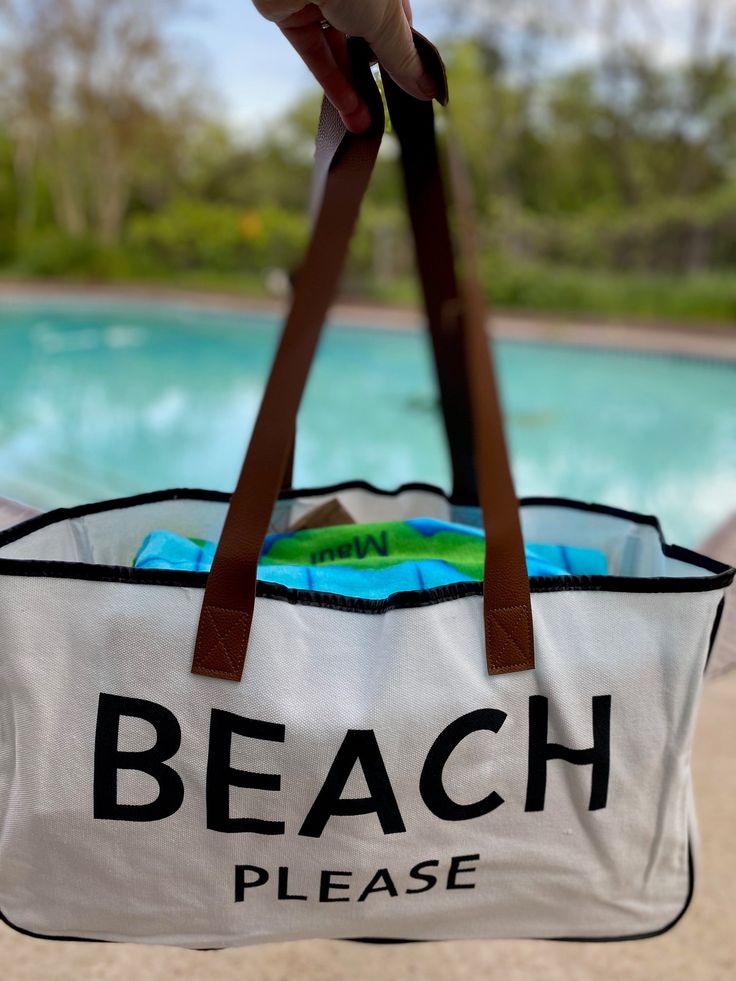 The perfect accompaniment to your trips to the shore, the lake or a weekend getaway - this "BEACH PLEASE" large canvas tote bag! It's perfect for carrying your seashells, beach reads, and other beach necessities. It's lightweight, durable, and stylish - you'll be prepared for any adventure! So grab your shades and your bag- BEACH PLEASE! Made of canvas and brown vegan leather 20" wide 11" tall 5" deep White Travel Bags For Beach Season, Large Capacity Canvas Beach Bag, Sand-colored Travel Bags For Beach Season, Large Capacity Bucket Canvas Bag For The Beach, Large Capacity Cotton Beach Bag For Travel, Large Capacity Bucket Canvas Bag For Beach, Summer Travel Canvas Bag With Canvas Lining, Summer Canvas Bag With Canvas Lining For Travel, Summer Canvas Weekender Bag For Travel