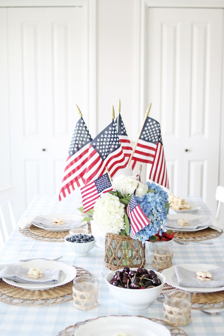 an american flag centerpiece sits atop a table with plates and desserts on it