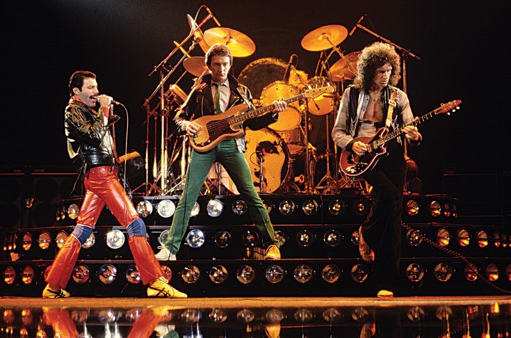 the rock band queen performing on stage with their guitars and drums in front of them