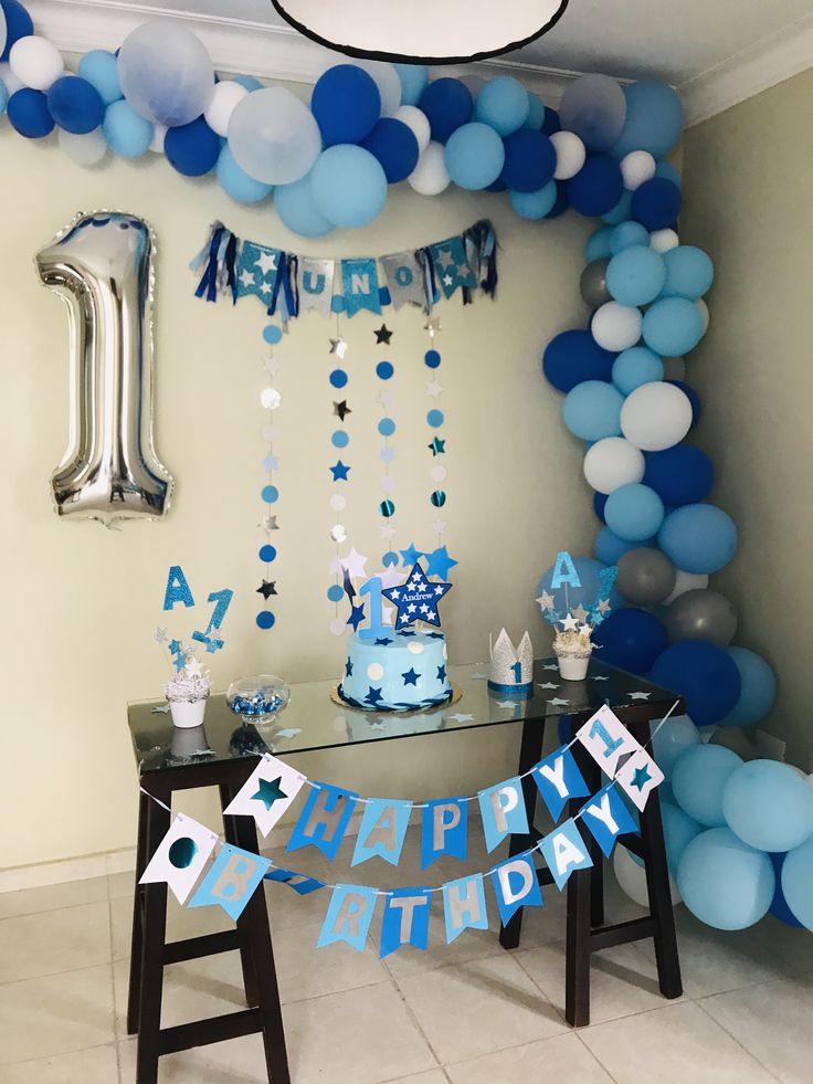 a blue and white birthday party with balloons