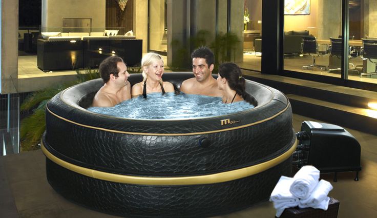 three people sitting in a large hot tub