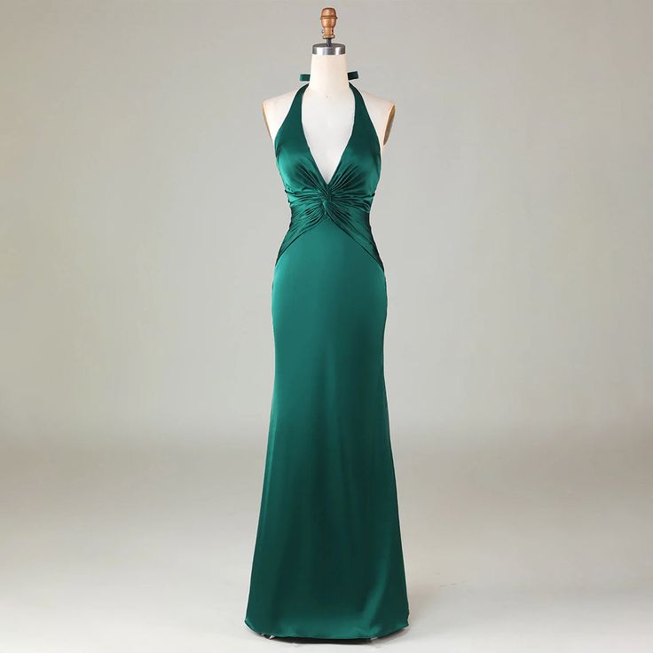 a green evening gown on display in front of a mannequin's head