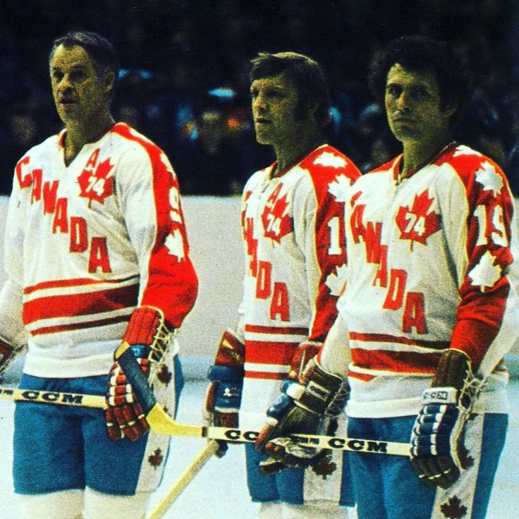 three men in canadian hockey uniforms standing next to each other