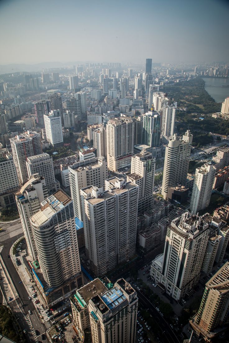 an aerial view of some very tall buildings in a big city with lots of windows