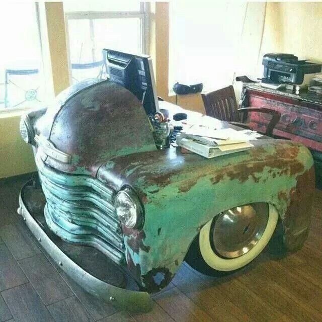 an old green car is sitting on the floor