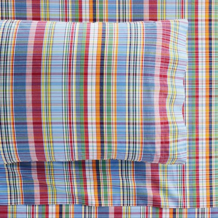 the multicolored plaid bedding is neatly made and ready to be used in any room