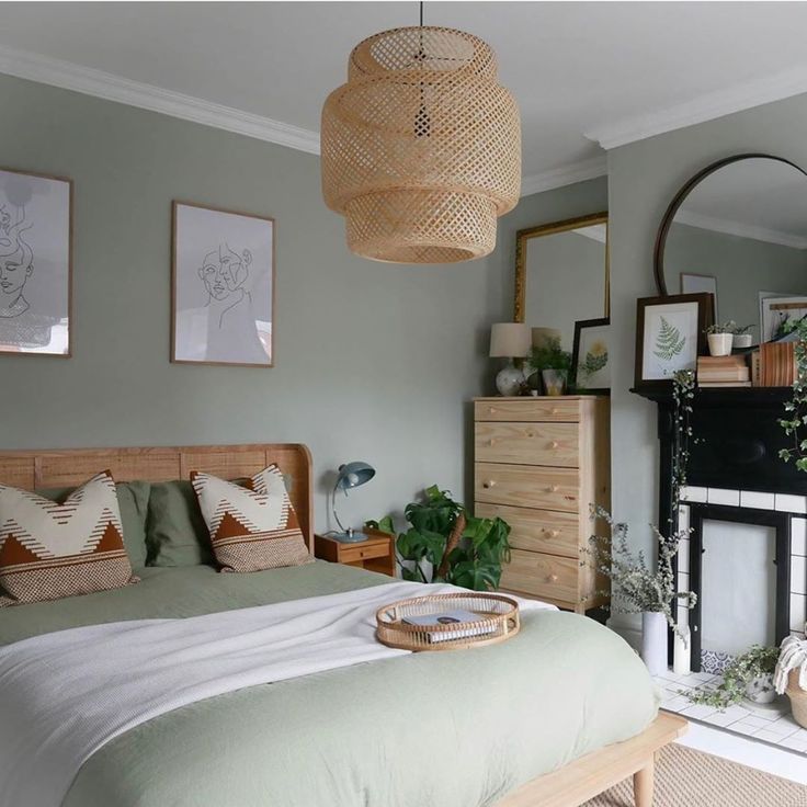 a bedroom with a bed, dresser and mirror on the wall next to a fireplace