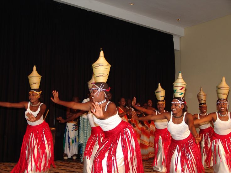 a group of women in red and white dresses dancing with their hands up to the side