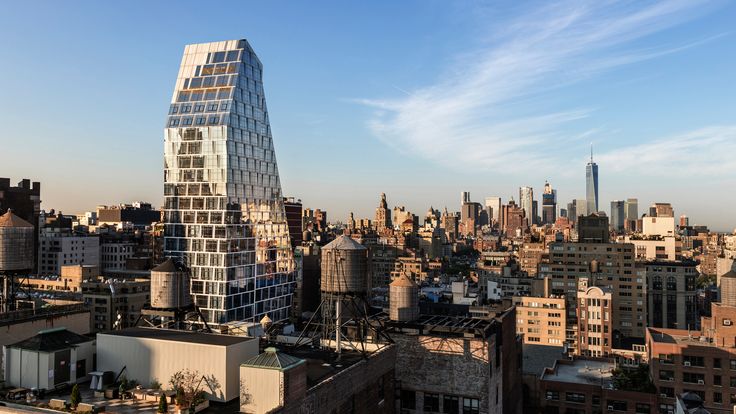 an aerial view of a city with skyscrapers and buildings in the foreground, against a blue sky