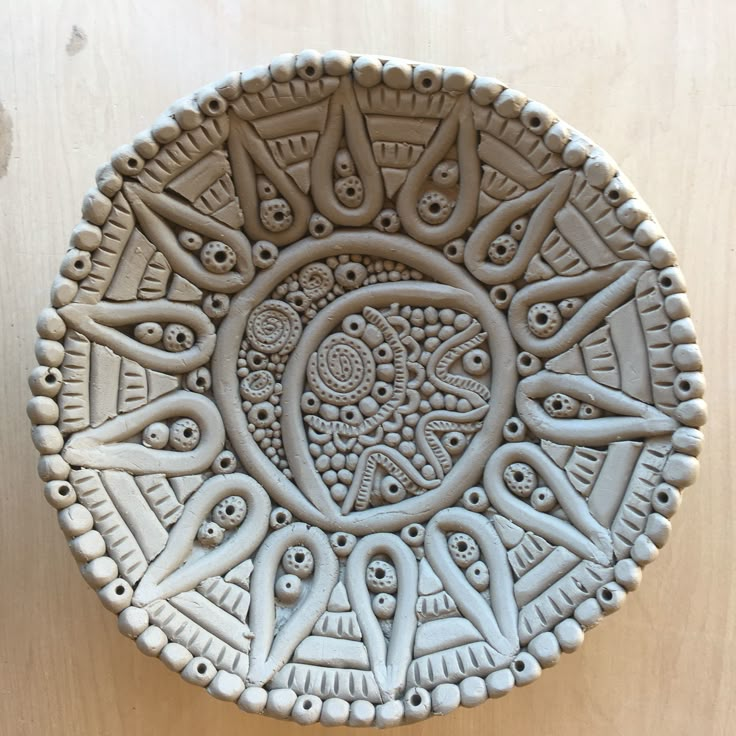 a decorative bowl sitting on top of a wooden table