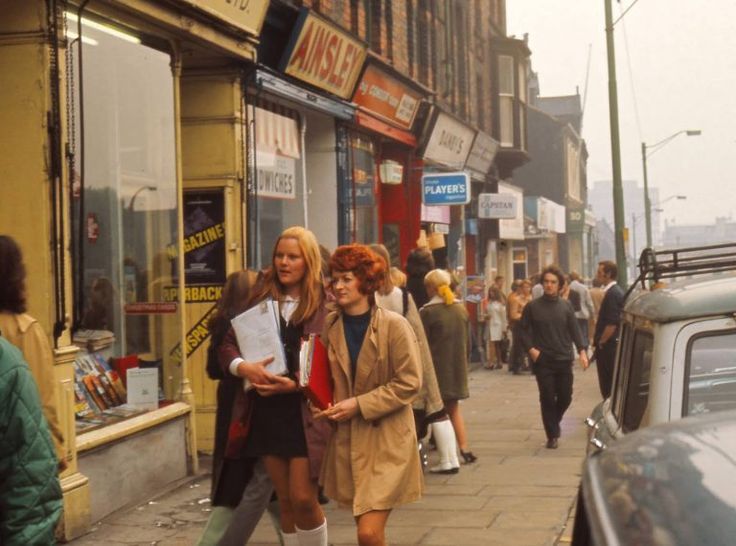 two women walking down the street in front of shops