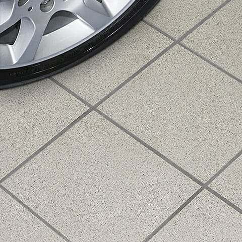 a close up of a car's tire on the ground near a tile floor