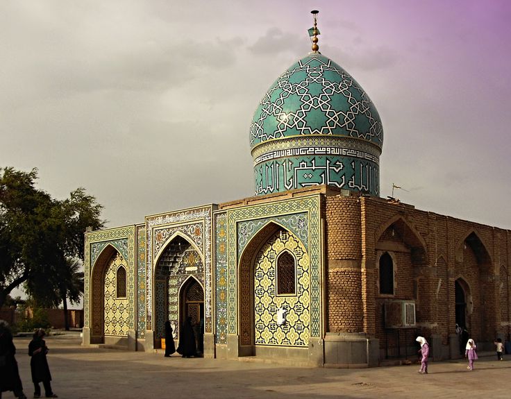 people are walking around in front of a building with a green dome on it's roof