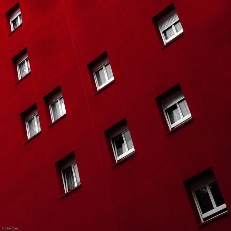 several windows on the side of a pink building