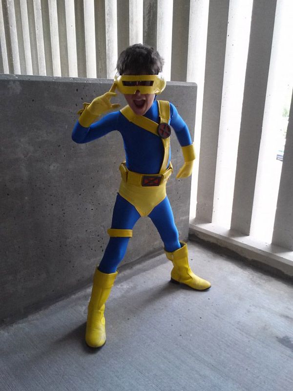 a man in a blue and yellow costume standing next to a wall