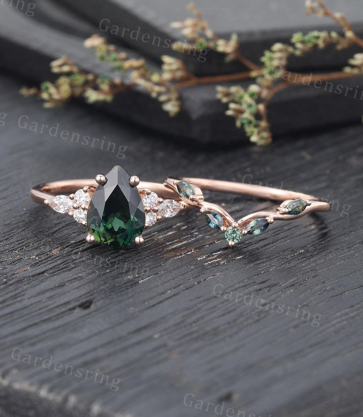 a green ring with leaves on it sitting on top of a wooden table next to a twig