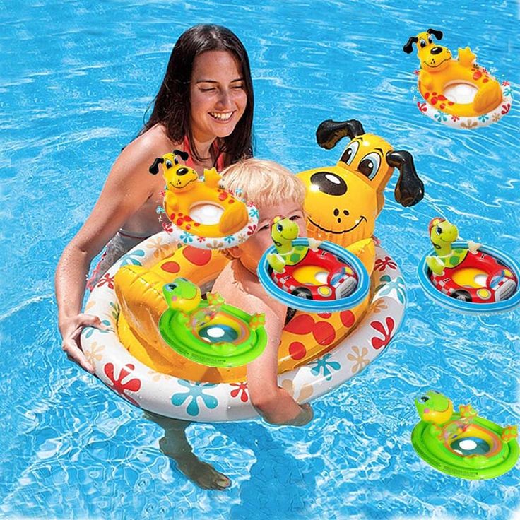 a woman holding a child in an inflatable pool with toys floating on it