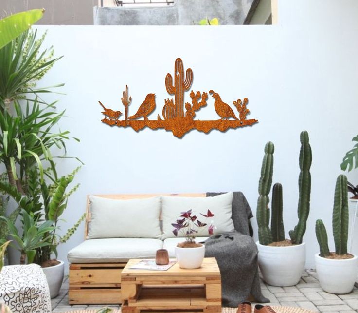 a living room filled with lots of plants next to a wall mounted wooden bird decoration