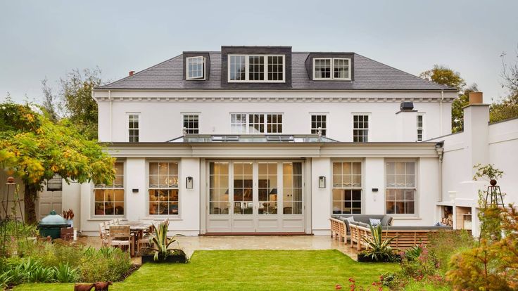 a large white house sitting on top of a lush green field