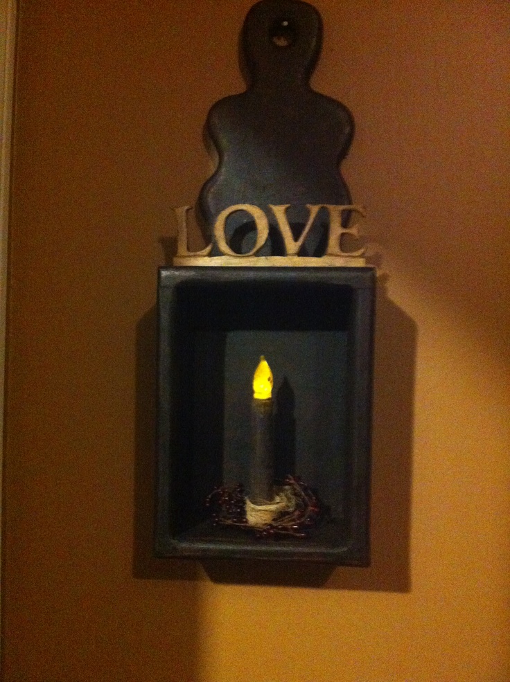 a light that is on the side of a wall next to a sign reading love