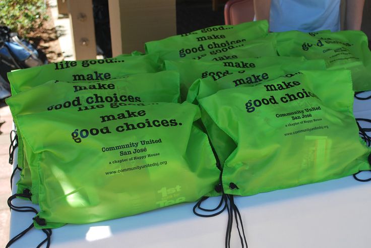 five green bags with good choices written on them sitting on a white table top next to some chairs