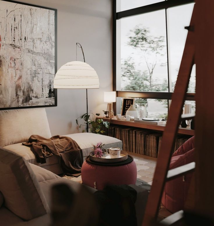 a living room filled with furniture next to a large window and a ladder in front of it