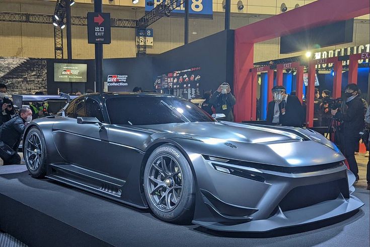 a silver sports car on display at an auto show