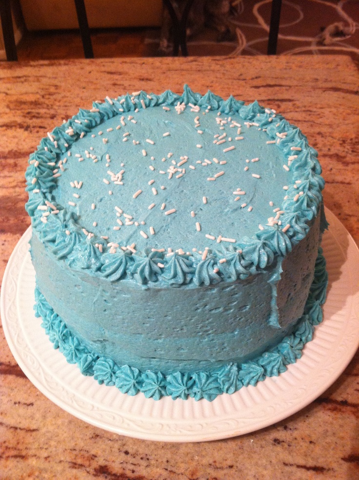 a blue frosted cake sitting on top of a white plate