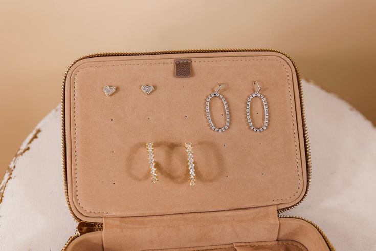 an open suitcase filled with jewelry on top of a table