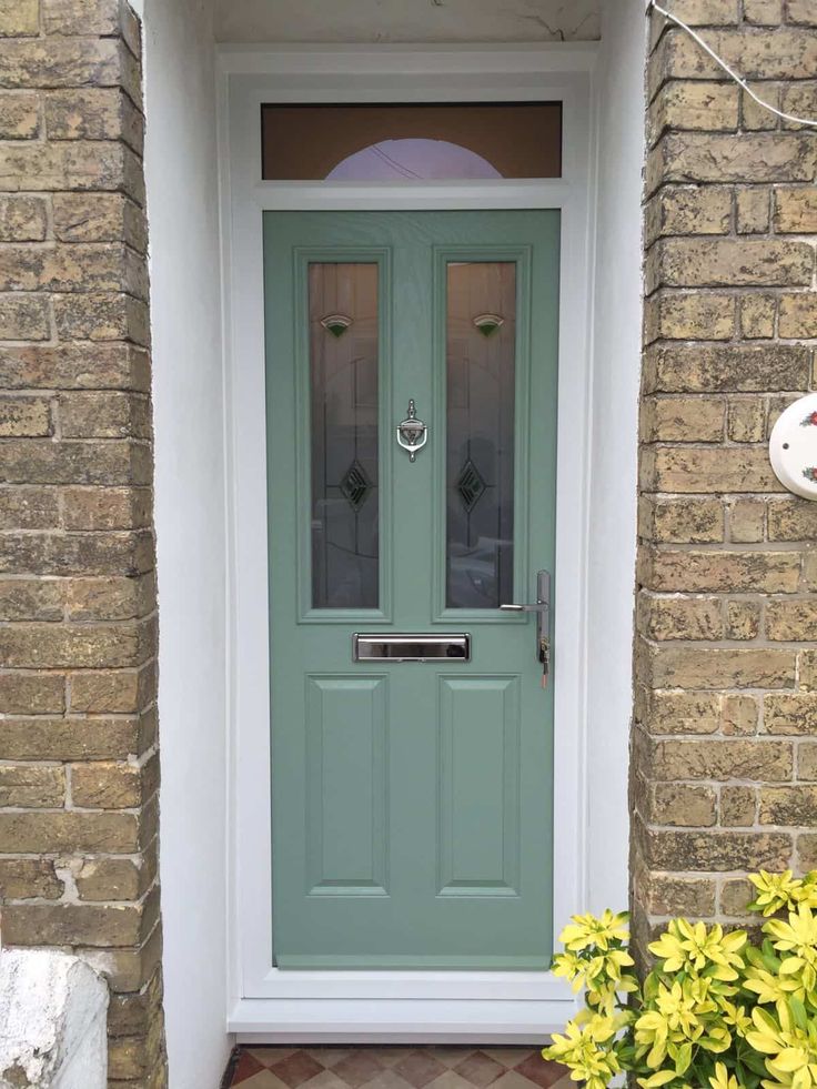 a green front door sitting next to a brick building