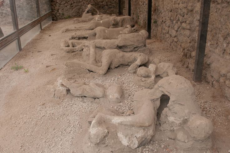 there are many statues in the sand near each other on the ground and one is laying down