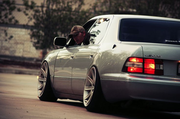 a man driving a silver car down a street