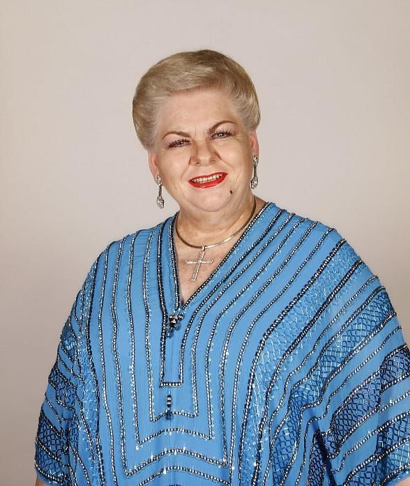 an older woman wearing a blue top with silver stripes on her shoulders and red lips