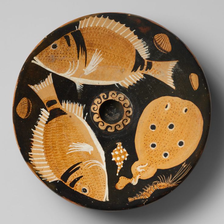 a black and yellow vase with fish on it