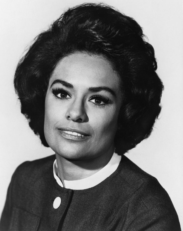 an old black and white photo of a woman with dark hair, wearing a sweater