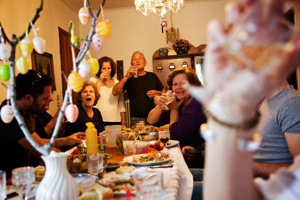 a group of people sitting around a table with food and drinks in front of them