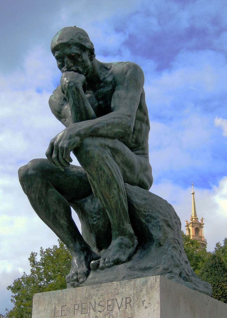 a statue of a man sitting on top of a cement block