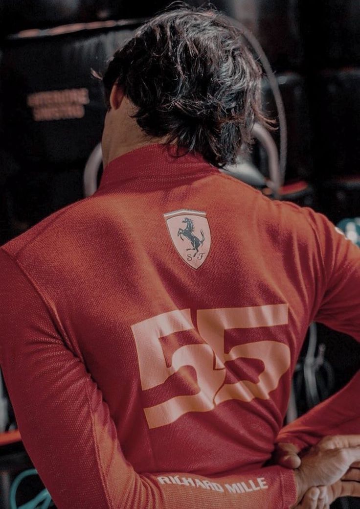 a man wearing a red shirt with the number 55 printed on it's back