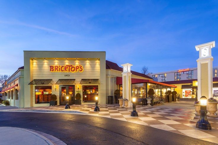 an empty shopping center at dusk with lights on