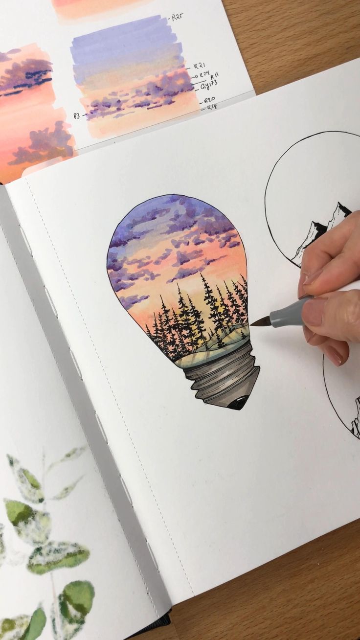 a person is drawing an image with watercolors on paper and using a pencil