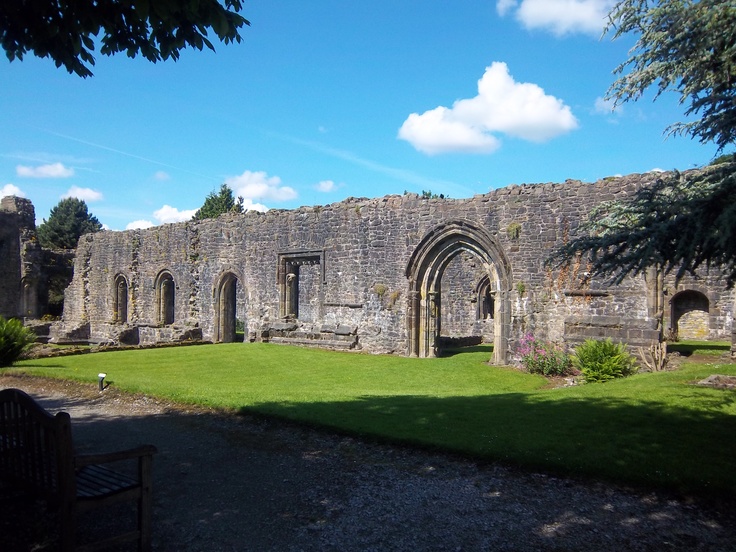 an old stone building sitting on top of a lush green field