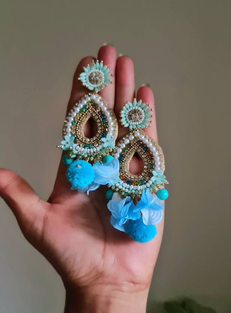 Bohemian handmade statement turquoise blue embellished large earrings. These beautiful turquoise earrings are hand crafted beautifully using various material like fabric, glass, chatton,pompoms etc. An ideal summer party earrings The earrings measure approx. 3.80" long and 2.20" wide. At Carnation jewellery, each piece is artisan handcrafted with love and care and shipped from India.  * SHIPPING - Please refer to the "announcement" page of the store. * Please be noted all kind of taxes, custom duties, VAT etc will be borne by the buyer as I am not responsible for the same. * For queries, please reach out to me and I shall revert ASAP. * PLEASE READ CAREFULLY THE SHOP ANNOUNCEMENT. Back to the store https://www.etsy.com/your/shops/ Carnation jewellery Handmade Blue Chandelier Earrings, Blue Handmade Danglers For Festive Occasions, Traditional Handmade Blue Danglers, Handmade Blue Danglers For Wedding, Bohemian Bridal Earrings For Wedding, Bohemian Drop Earrings With Handmade Flowers, Bohemian Jewelry With Handmade Flowers Drop Earrings, Turquoise Chandelier Earrings For Festivals, Handmade Bohemian Flower Earrings For Party