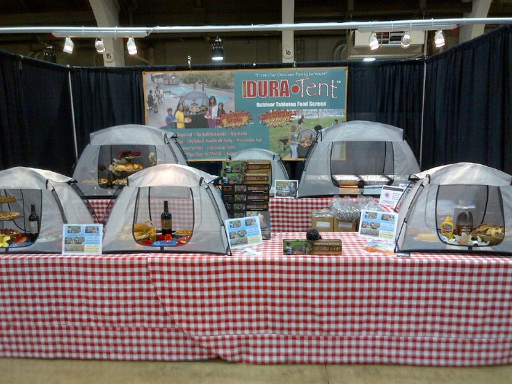 several tents set up on top of a checkered table cloth with food in them